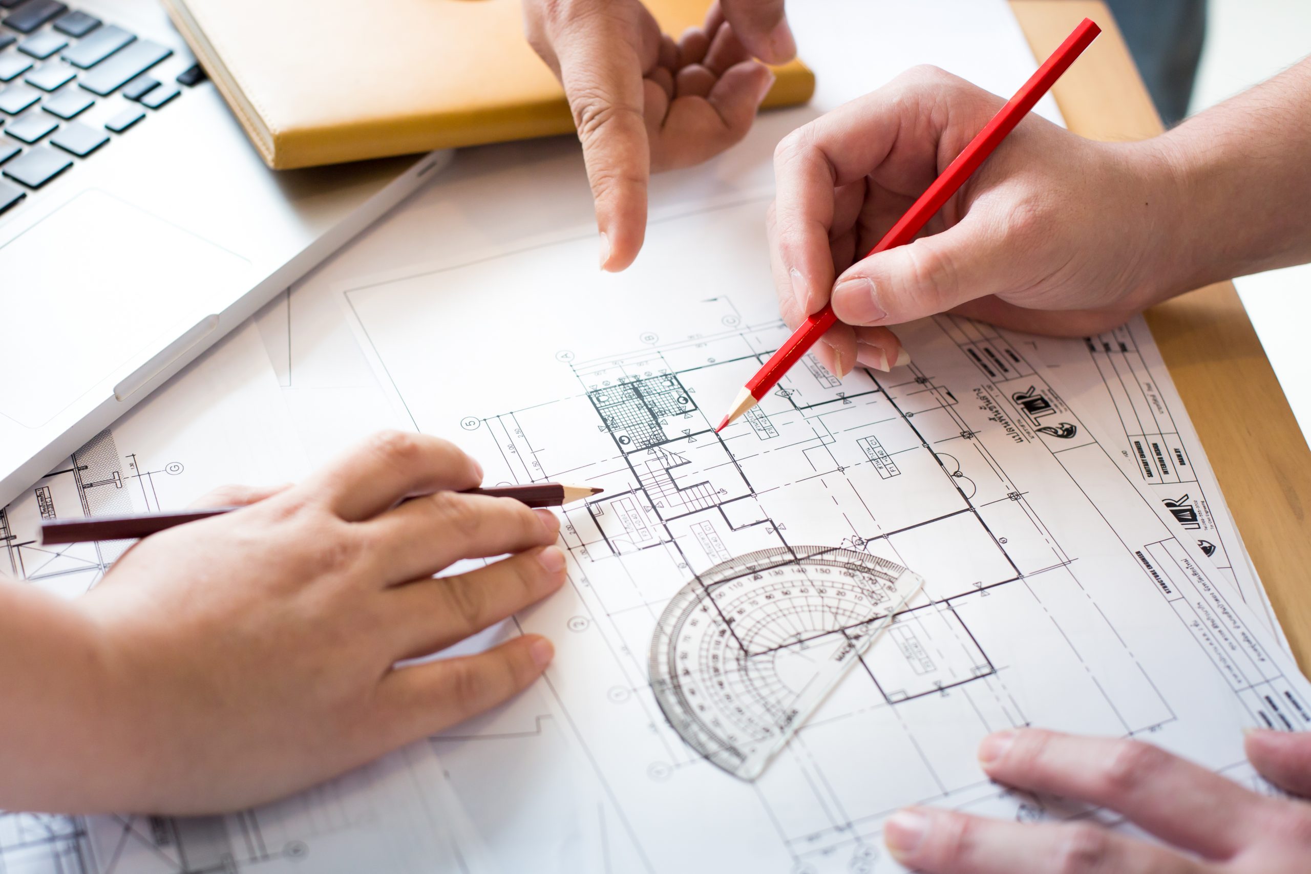 Architects discussing at the table with blueprint - Closeup on h